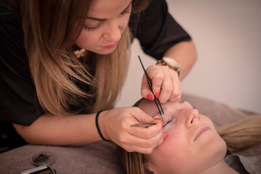 A beauty therapist applying lashes